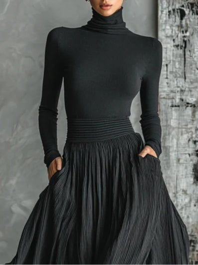 Conjunto de moda completamente negro con camiseta ajustada de cuello alto y falda plisada